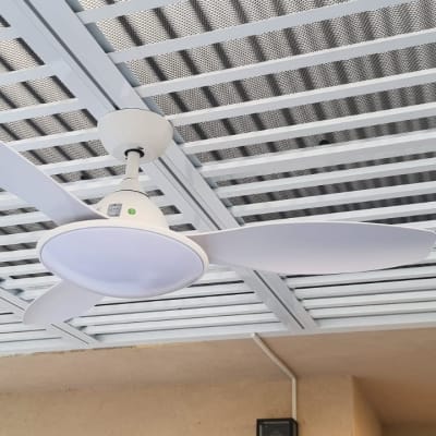 מאוורר תקרה לבן מותקן על תקרה עם רשת מתכת