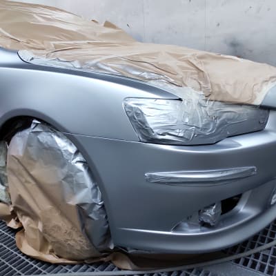 רכב מכוסה בנייר לקראת צביעה במוסך