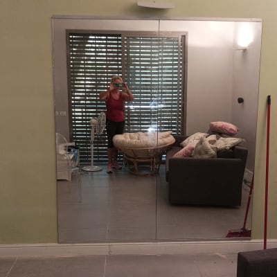 קיר ירוק עם מראה גדולה ומטאטא אדום