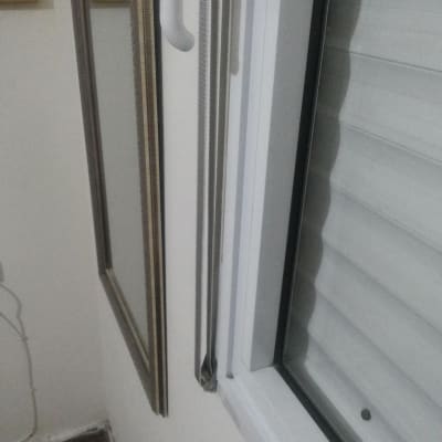 תריסים לבנים עם ידית פתיחה על חלון