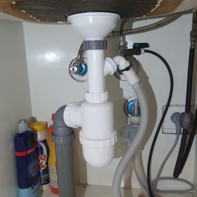 צנרת פלסטיק מתחת לכיור עם חיבורים ואביזרים