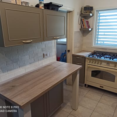 מטבח משופץ עם ארונות חדשים ומשטח עבודה מעץ