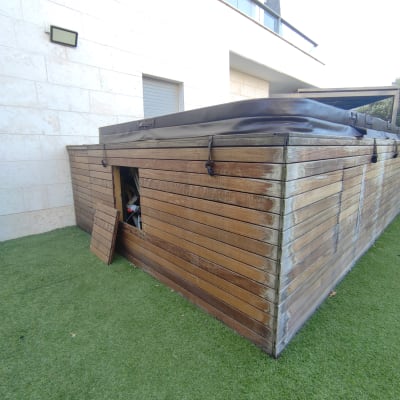 מבנה עץ עם דלת פתוחה על דשא סינתטי