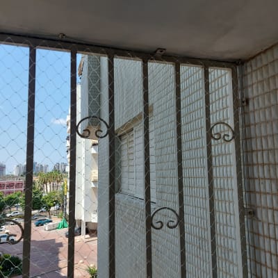 רשת מתכת על חלון למניעת כניסת יונים