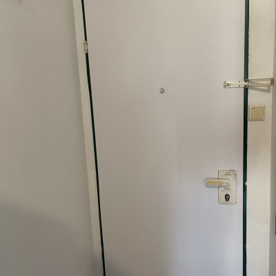 דלת לבנה עם ידית ומנעול, מסגרת כהה