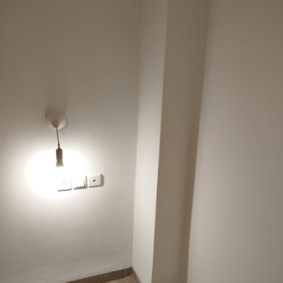 קיר צבוע בלבן עם שקעי חשמל ונורה