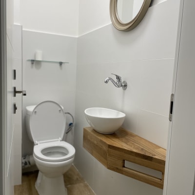 שירותים עם כיור עגול על מדף עץ