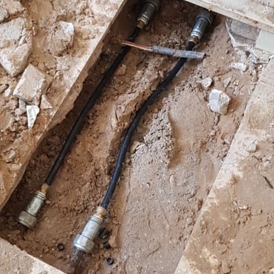 צינורות מים חשופים בתוך רצפה שבורה