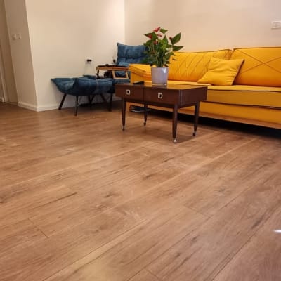 רצפת פרקט עץ חום בסלון מודרני עם ספה צהובה