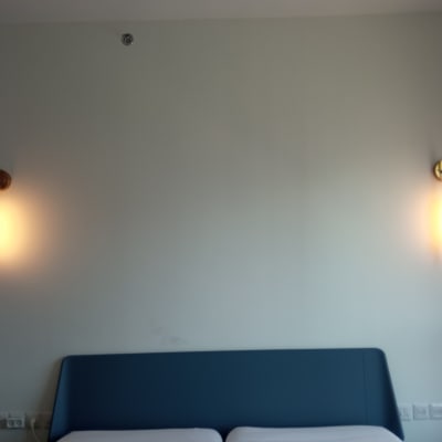 שני מנורות קיר דולקות על קיר לבן