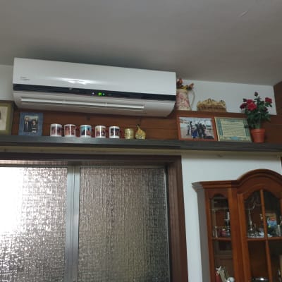 מזגן מותקן על קיר מעל מדף עם חפצים