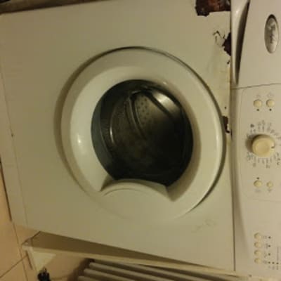 מכונת כביסה לבנה עם כפתורים ולוח בקרה