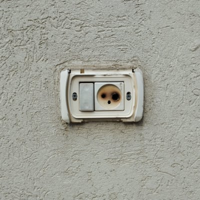 שקע חשמלי בקיר עם כיסוי פגום