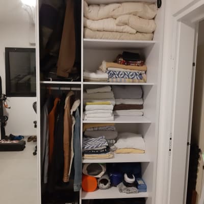 ארון בגדים עם בגדים מקופלים ומעילים תלויים