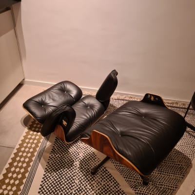 כורסה והדום עור שחור על שטיח מעוצב