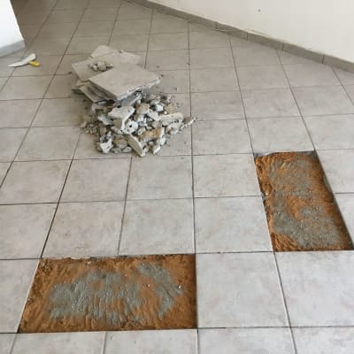 רצפה עם אריחים שבורים ועבודת תיקון