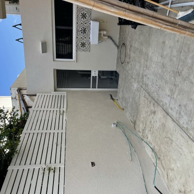 קיר חיצוני צבוע בצבע בהיר עם צינורות חשופים