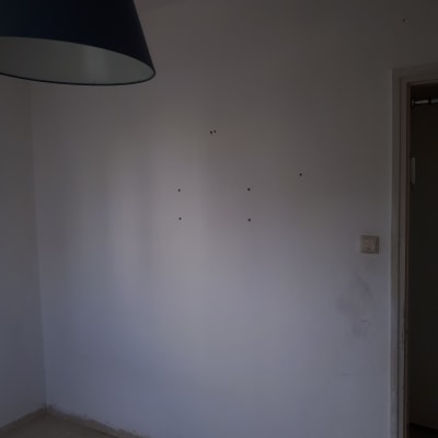 קיר לבן עם חורים קטנים וכתמים