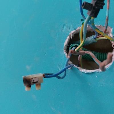 חוטי חשמל צבעוניים יוצאים מקיר