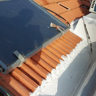 גג רעפים עם לוחות סולאריים וצבע לבן לאיטום