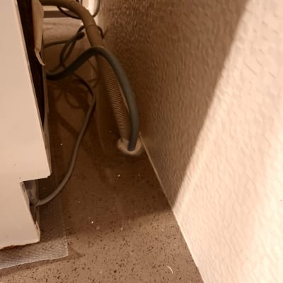 צינור מים מחובר לקיר ליד מכשיר חשמלי