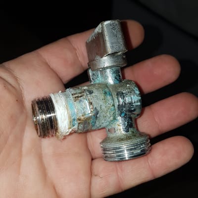 ברז מתכת חלוד מוחזק ביד של אדם