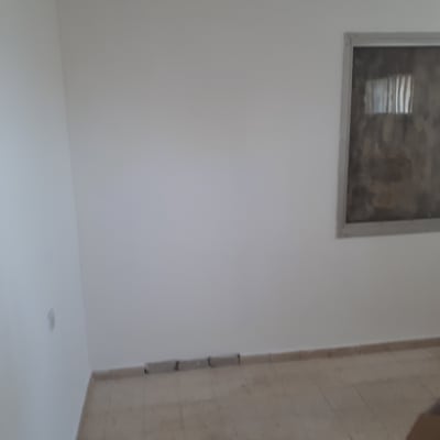 קיר צבוע בלבן עם חלון כהה