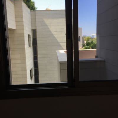 חלון אלומיניום פתוח עם נוף לבניינים חיצוניים