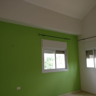 קיר צבוע בירוק עם חלונות לבנים