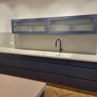 מטבח עם ארונות כחולים וברז שחור