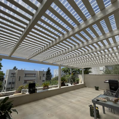 מרפסת עם פרגולה מעץ, עציצים וכלי עבודה