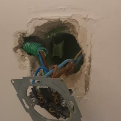 חוטי חשמל יוצאים מקופסת חשמל בקיר