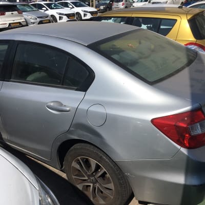 מכונית אפורה עם שריטות על הפגוש האחורי