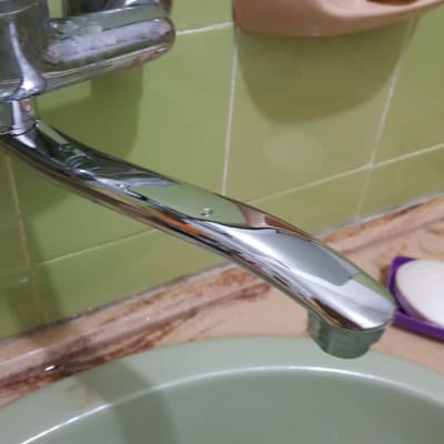 ברז כרום מעל כיור ירוק בחדר אמבטיה