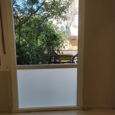 חלון אלומיניום עם זכוכית חלבית וכלי עבודה על הרצפה