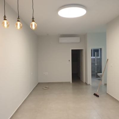 חדר ריק עם מנורות תלויות ומטאטא על הרצפה