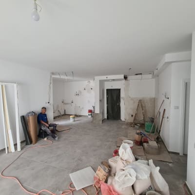 חדר בשיפוץ עם קירות חשופים, סולמות וחומרי בניין