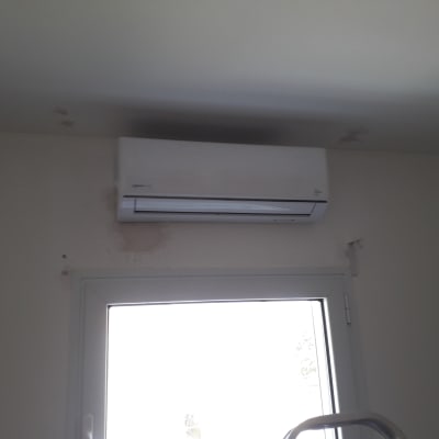 מזגן מותקן על קיר מעל חלון