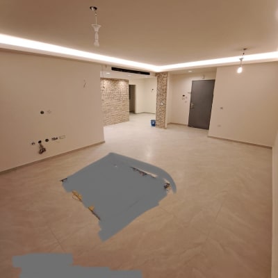 חדר עם קירות לבנים, תקרה מוארת, רצפת אריחים, חוטי חשמל גלויים.