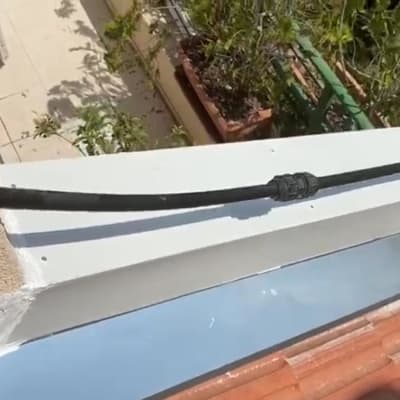 כבל שחור על גג רעפים עם לוח מתכת