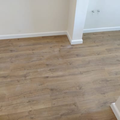 רצפת פרקט עץ בהירה בחדר ריק עם קירות לבנים