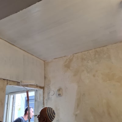 קיר גבס צבוע בלבן עם רולר צביעה