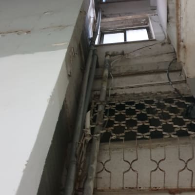 צינורות מתכת מותקנים על קיר חיצוני של בניין