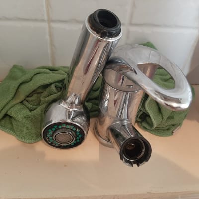 ברז מתכת מונח על מטלית ירוקה