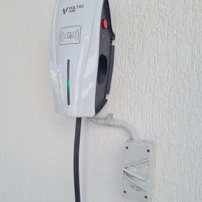 מטען לרכב חשמלי מותקן על קיר עם כבל חשמל