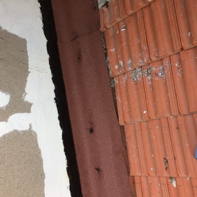 רעפים כתומים על גג עם סימני שחיקה