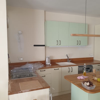 מטבח בשיפוץ עם ארונות ירוקים, כיור וברז מותקנים