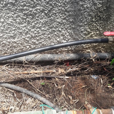 צינור שחור עם ברז אדום וחיבורים מתכתיים