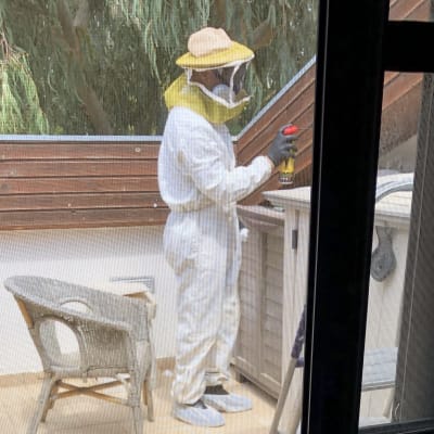 אדם בחליפת מגן מרסס חומר הדברה