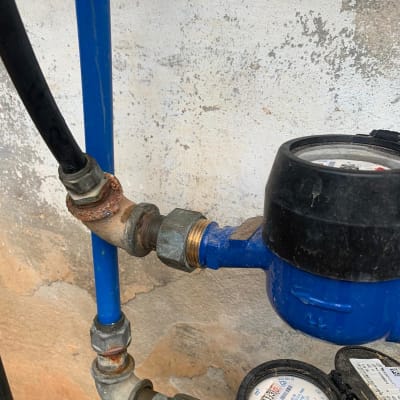 מד מים כחול עם צינורות מתכת מחוברים